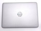 a white laptop with a silver hp logo on the screen