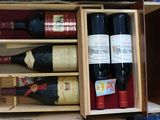 many bottles of wine in a wooden box on a table