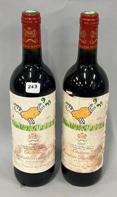 two bottles of red wine sitting next to each other on a table