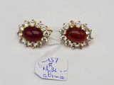 a pair of red and white stone earrings on a white surface
