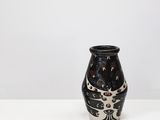 a black and white vase sitting on a white surface