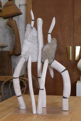 une table en bois sur laquelle se trouvent une sculpture et un vase