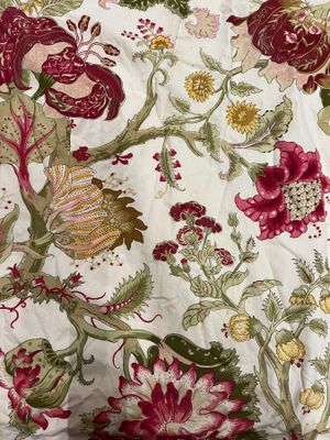 an image of a bed with a white and red floral comforter on it