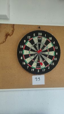 a dart on the wall next to a dart board