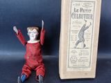 une petite poupée assise à côté d'une boîte