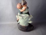 a figurine of a boy and a girl sitting on a tree stump