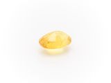 a yellow sapphire stone on a white background