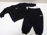 a black sweatshirt and pants are laying on a white surface