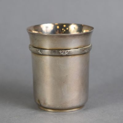 an antique silver cup with a silver band around the rim