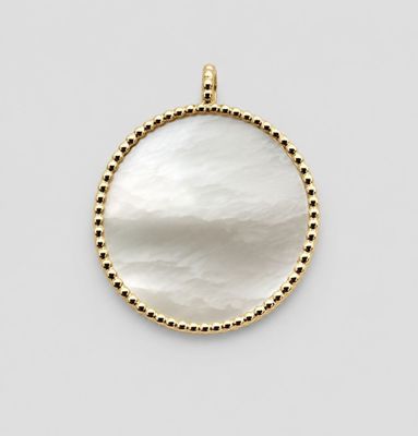 a white mother of pearl pendant with gold dots