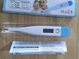 a digital thermometer sitting on a table next to a box of toothpaste