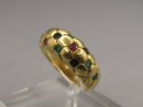 an image of a gold ring with multicolored stones on it