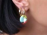un gros plan sur l'oreille d'une femme portant une paire de boucles d'oreilles