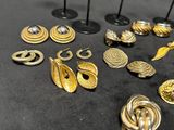 several different types of earrings are displayed on a black surface