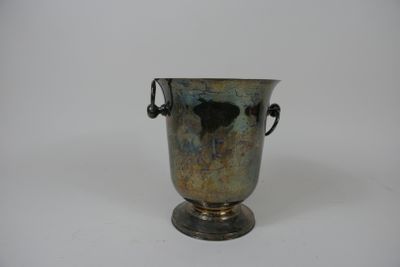 un vase en argent posé sur une surface blanche