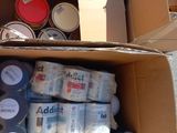 a cardboard box filled with cans and cans of paint