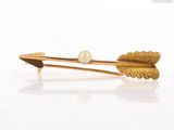 a gold hair clip with a pearl on it