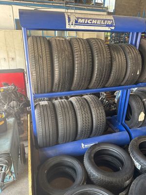 des pneus sont empilés sur un chariot bleu dans un garage