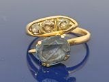 paire de bagues en or ornées d'une pierre bleue et de diamants sur un fond bleu