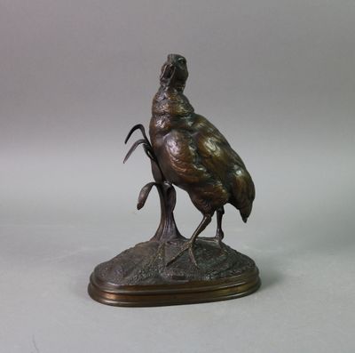 bronze statue of a bird on a rock on a white background