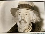 a black and white photo of a man wearing a hat