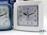 two alarm clocks sitting next to each other on a table