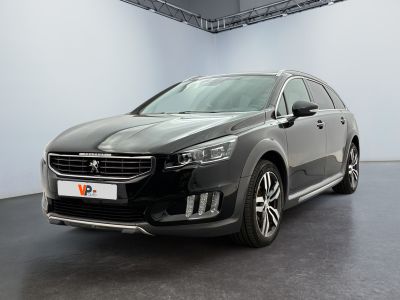 the black car is parked in a large room with white walls