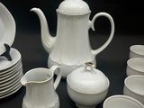 a lot of white dishes and cups on the table