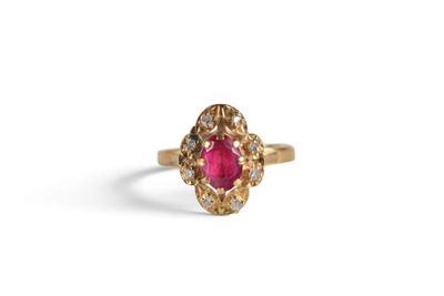 a close up of a gold ring with a ruby stone