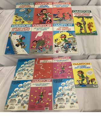 une pile de livres pour enfants posée sur un lit aux draps blancs