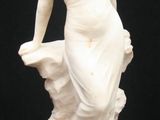 a statue of a woman holding a basket on a black background