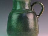 a green vase that is sitting on a table