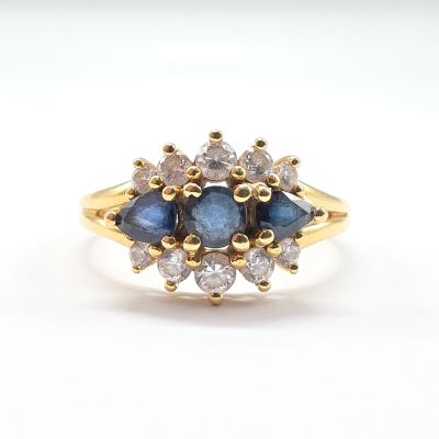a close up of a yellow gold ring with blue and white diamonds