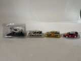 four toy cars are lined up in a row on a table