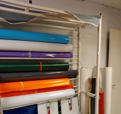 de nombreux rouleaux de papier coloré posés sur une étagère dans une pièce