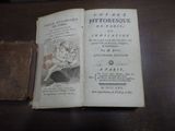 un vieux livre posé sur une table à côté d'un autre vieux livre