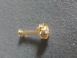 a close up of a gold nose ring with a single diamond