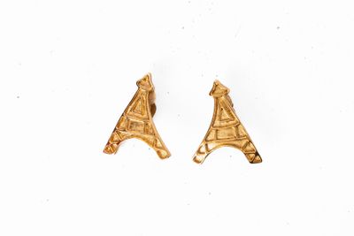 une paire de boucles d'oreilles en or sur fond blanc