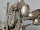 a lot of silver spoons and forks on the table