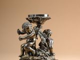 an image of a silver statue of a boy and a girl holding a bowl