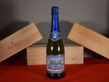 a bottle of wine sitting on a table next to a wooden box