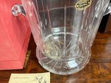 un pichet en verre transparent posé sur une table à côté d'une boîte rouge