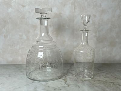 deux bouteilles en verre vides posées l'une à côté de l'autre sur une table