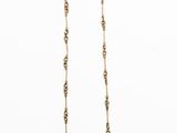 un long collier composé d'une longue chaîne ornée de perles