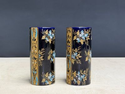 une paire de vases bleus et dorés posés sur une table en bois