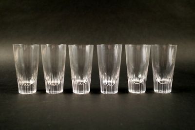 six verres à shot alignés sur une surface noire