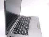 a silver laptop computer sitting on top of a white table