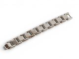 a close up of a metal bracelet on a white surface