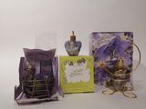 trois flacons de parfum et un sac cadeau posés sur une table