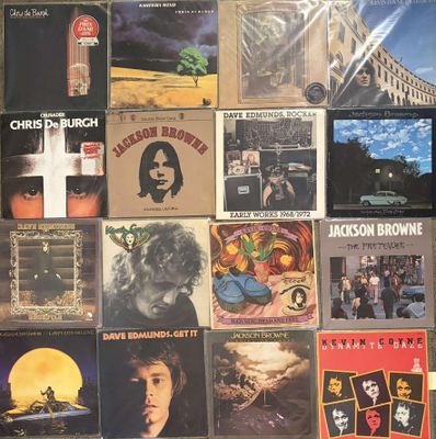 many different album covers on the wall of a room